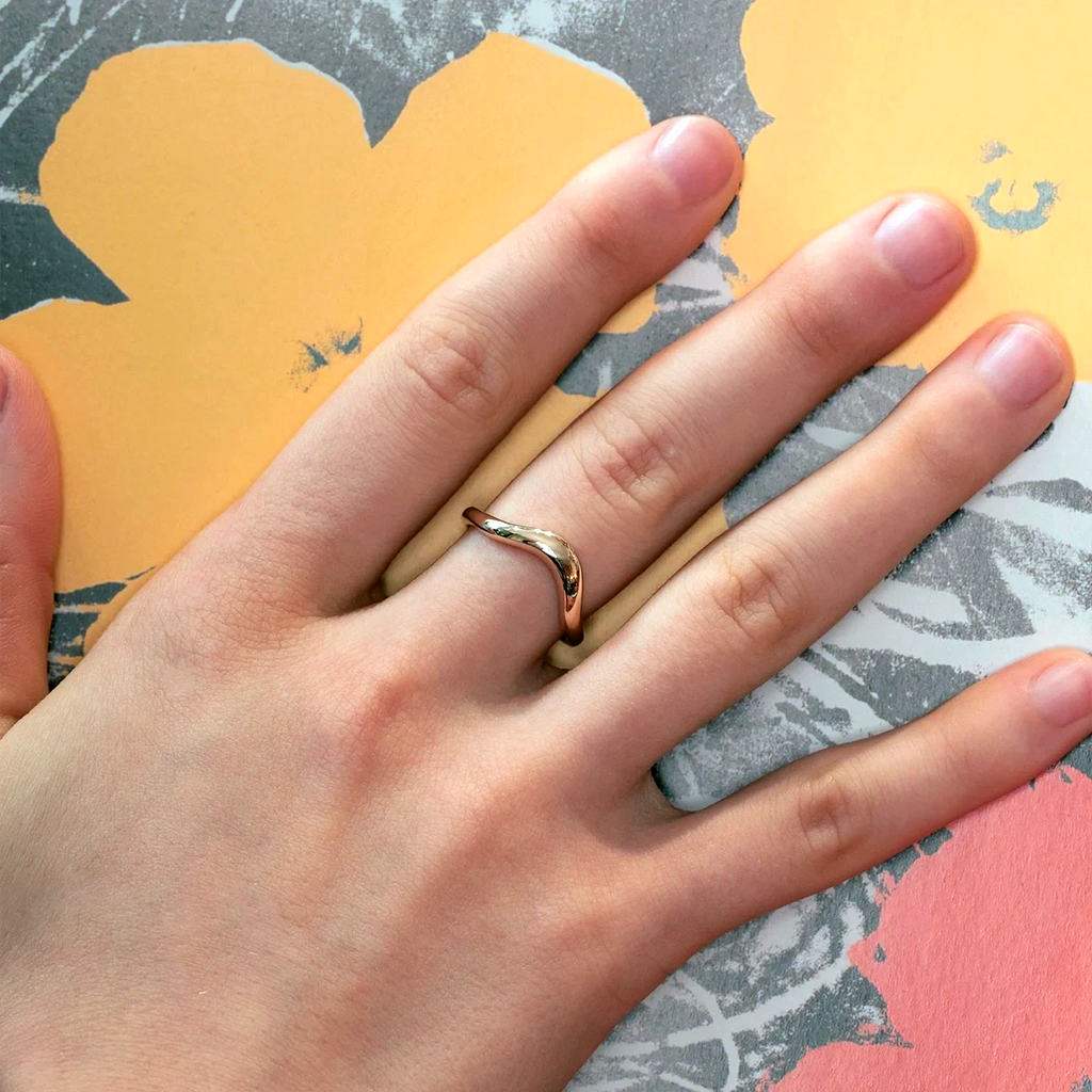Curved 14k gold wave band worn on a hand, designed by Canadian jeweller Yuliya Chorna. Available at Ruby Mardi, a fine jewelry boutique in Montreal, Canada.