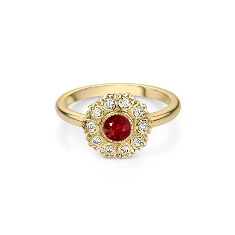 Ruby Mardi jewelry presents the Victoria ring, featuring a magnificent round ruby bezel set with multigrain detail, and an original diamond halo bezel set in a flower pattern. This handmade wedding ring is a creation of jewelry brand Bramston Goldsmithing and it was made in Canada. This regal piece of jewelry is available in our fine jewelry gallery in Montreal, Canada.