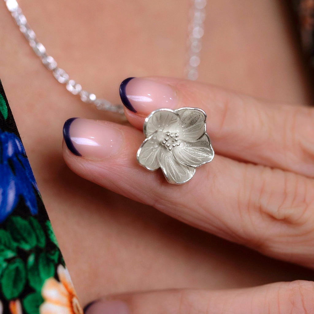 Close up of the white gold wood sorrel pendant by Fleurs Sauvages Qc, showing the detailed Oxalis petals. Independent floral jewelry available at Ruby Mardi Montreal.