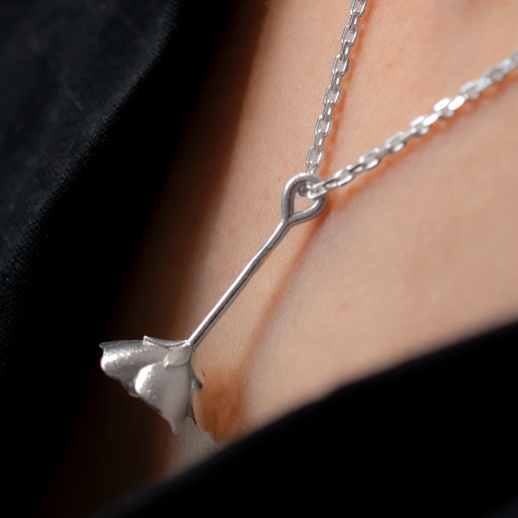White gold Oxalis wood sorrel pendant worn on a chain, crafted by Fleurs Sauvages Qc. Nature-inspired wildflower jewelry from Ruby Mardi Montreal.