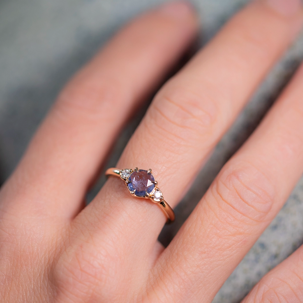 Unique light blue sapphire engagement ring with rose-cut center stone and diamonds, handcrafted in 14k yellow gold by Yuliya Chorna, shown at Ruby Mardi Montreal.