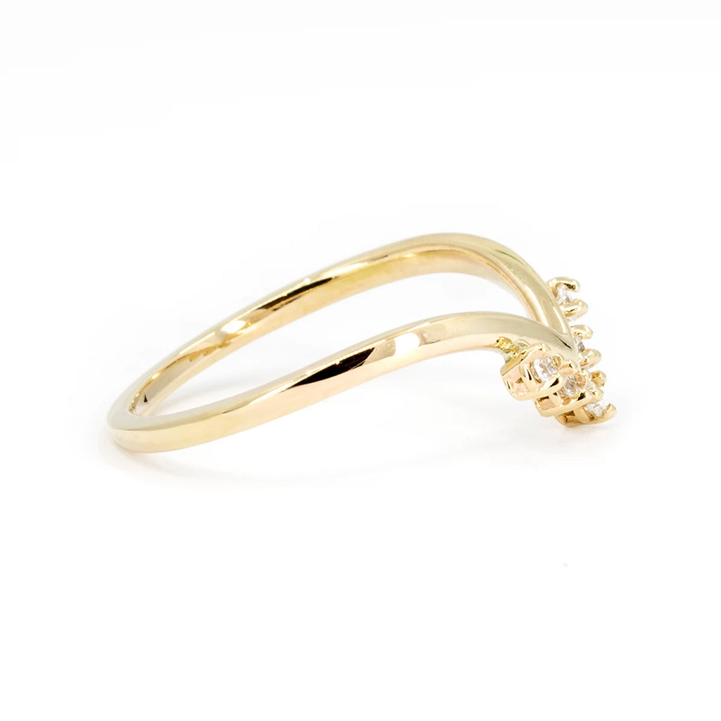 Side view on a white background of a V shape diamond wedding band in recycled 14k yellow gold. A design from American indie brand In the Light of Day Jewelry. This bridal piece of jewelry of a unique style is available at Ruby Mardi, a jewelry store in Montreal, Canada.