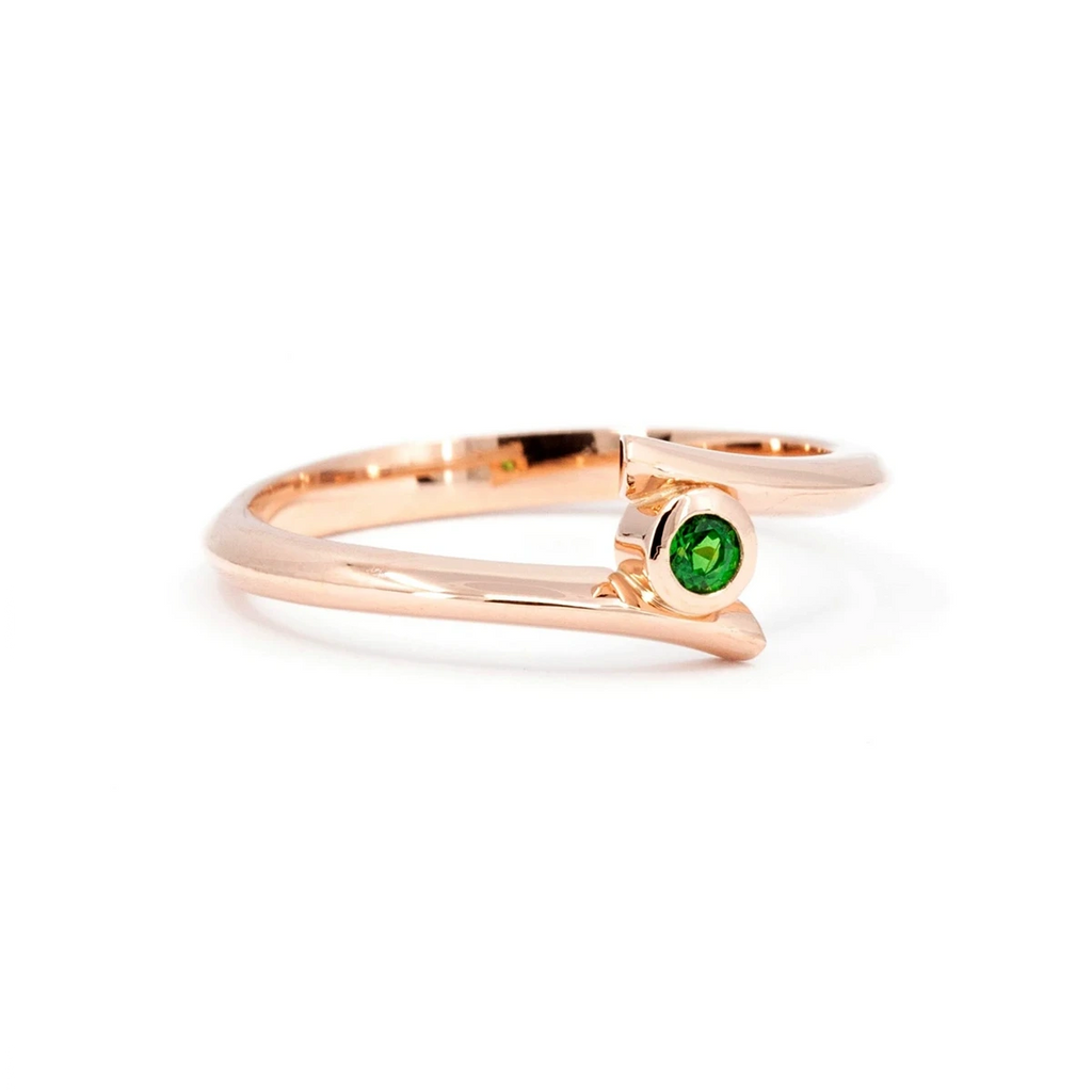 This one-of-a-kind ring with an edgy style and a twisted ring, is set with a green-colored dismantler garnet and mounted on pink gold. This wedding jewel is available for sale at the Ruby Mardi jewelry store in Rosemont and Villeray, specializing in fancailles rings from independent designers with colored gems.
