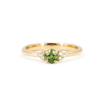Cushion shape green sapphire engagement ring with natural diamond accents, photographed on a white background. This bridal jewelry piece is handmade in Montreal  by independent brand and best jewelry store in Canada, Ruby Mardi. Unique jewelry and independent jewelry in Canada.