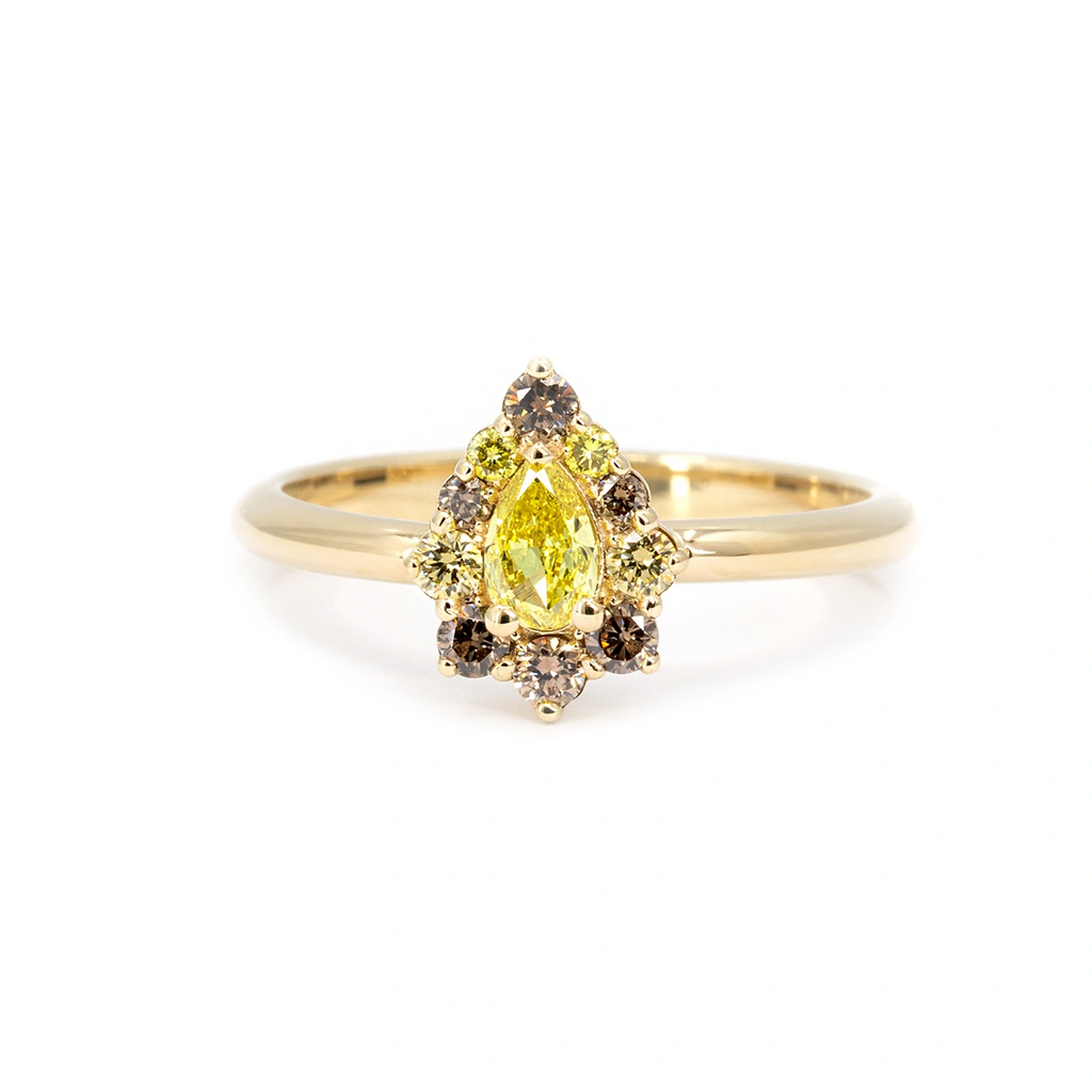 Pear-shaped yellow diamond ring with brown and yellow diamond halo set in yellow gold. Unique engagement ring available at Ruby Mardi, Montreal jewelry store.