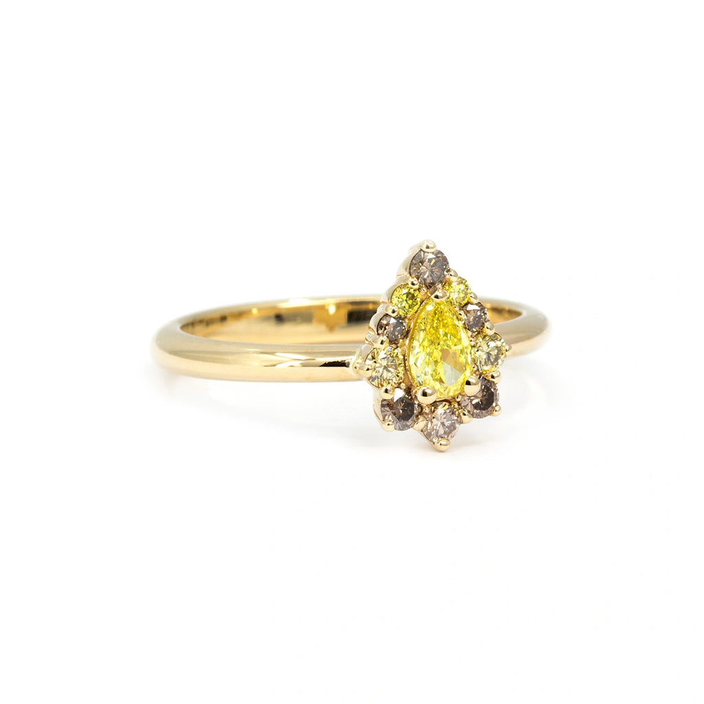 Side view of pear-shaped yellow diamond engagement ring with brown and yellow diamond halo, set in yellow gold. Unique fine jewelry by Ruby Mardi, Montreal.