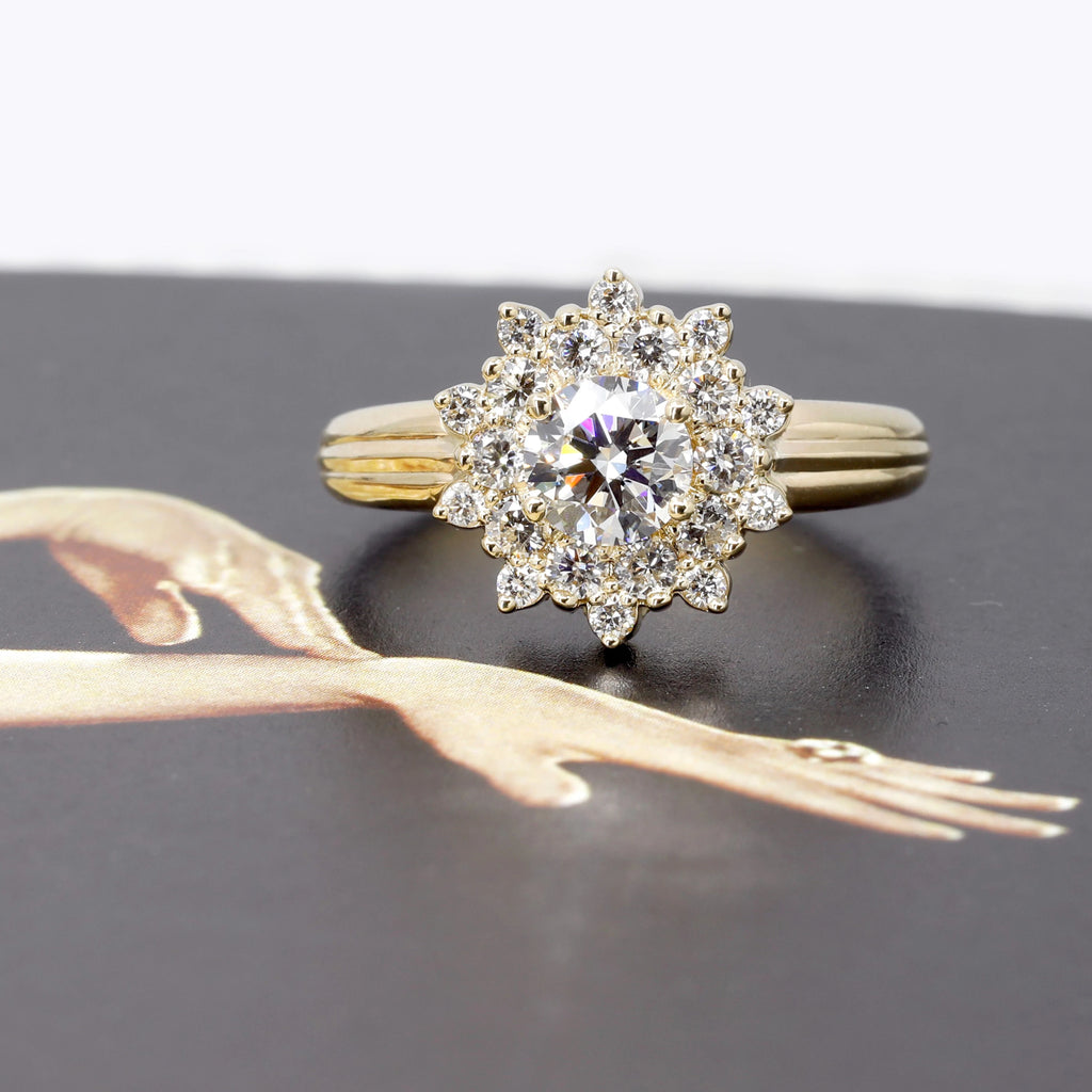 An all-diamond ring photographed on a picture showing elegant lady’s hands. The ring has a large band in yellow gold, and it has the shape of a sun. A big round diamond is surrounded by twenty smaller round diamonds, to form what resemble a sun. This alternative engagement ring or statement jewellery piece was designed and handmade by local brand Ruby Mardi, a fine jewellery store in Montreal’s Little Italy.