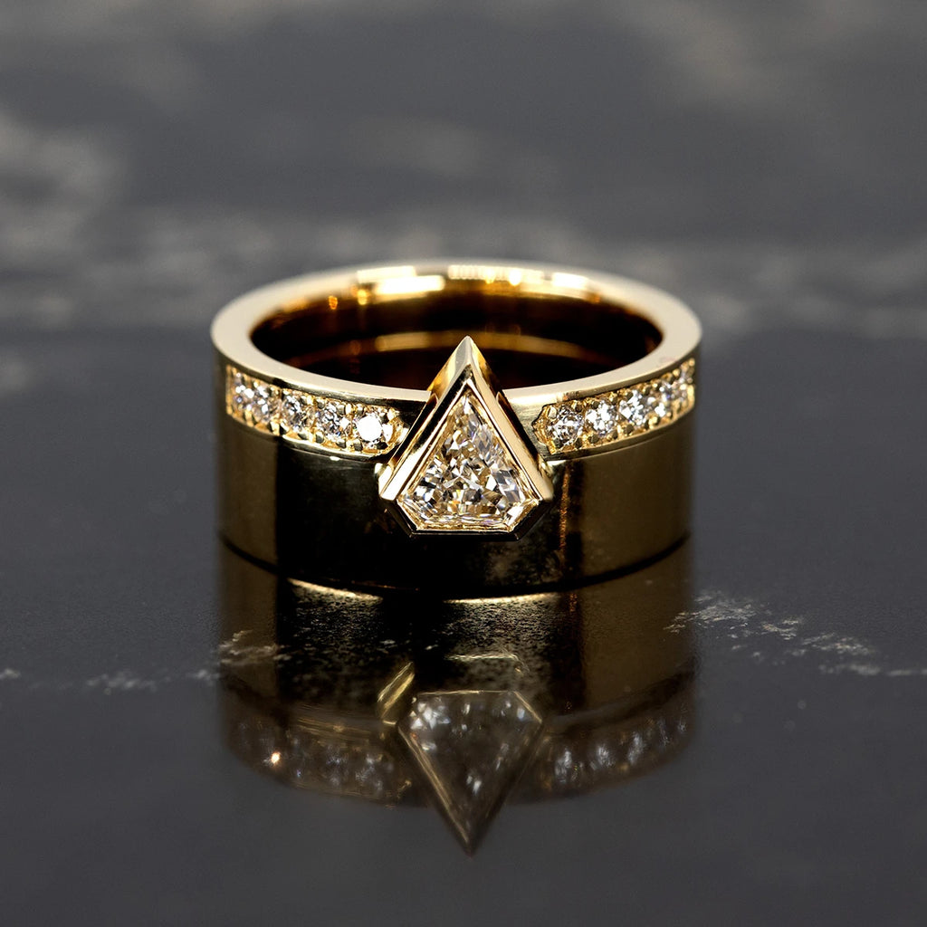 A gold open ring with 10 small diamonds is seen photographed on top of its matching ring: a chunky gold band mounted with a pentagonal lab grown diamond. This designer and modern set of fashion jewellery was designed in Montreal by Bena Jewelry and is seen here photographed on black marble.