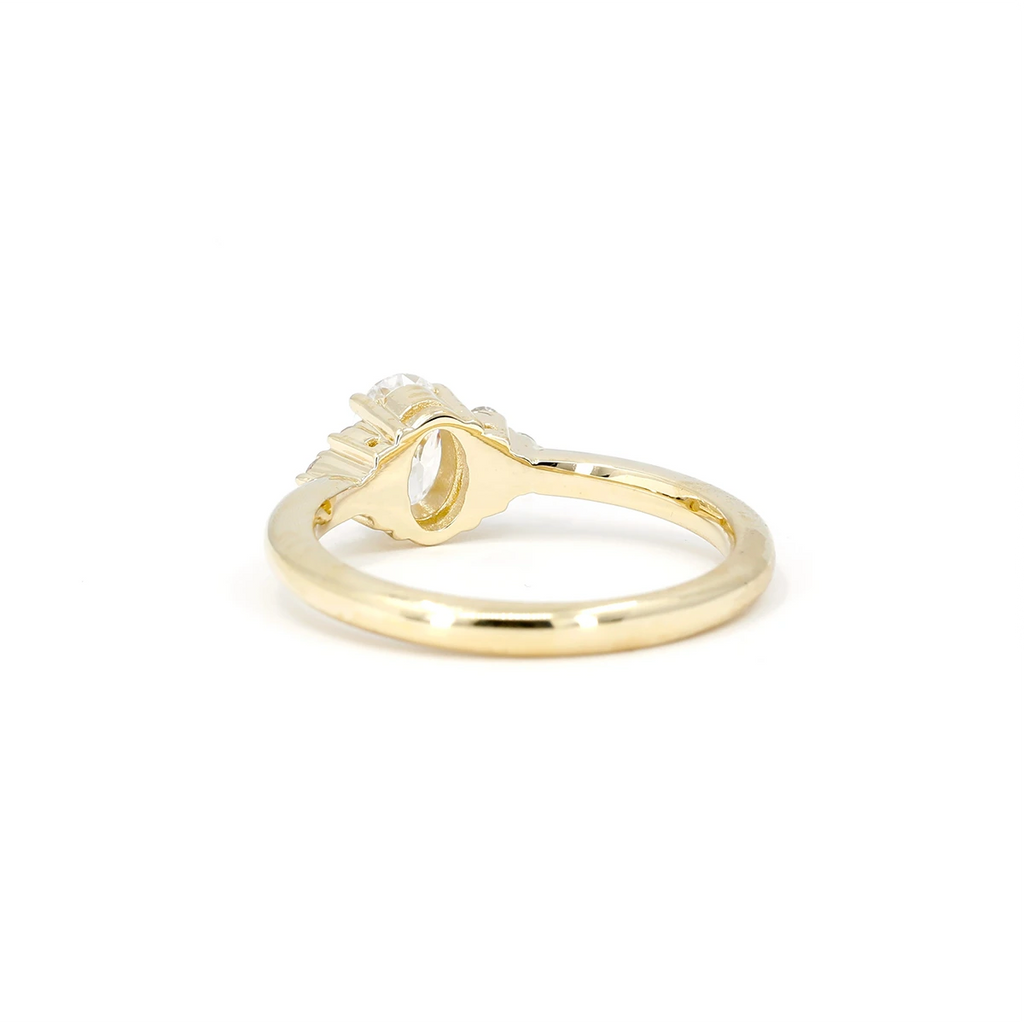 Rear view of the yellow gold engagement ring named Désir, handmade in Montreal by Boutique Ruby Mardi, a cool jewelry store that sells independent fine jewellery brands. This ring is made with a lab grown oval diamond by our team of jewellers.