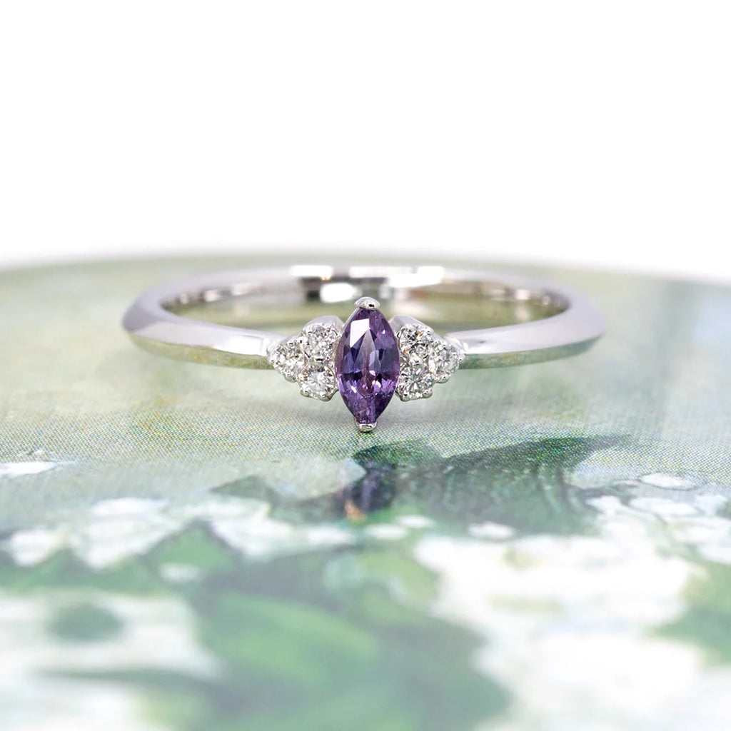 This engagement ring is made with a natural purple sapphire and small round diamonds. Mounted on white gold, this elegant bridal ring is made in Canada by the Ruby Mardi jewelry store in Montreal, specialist in fine jewelry from independent designers.