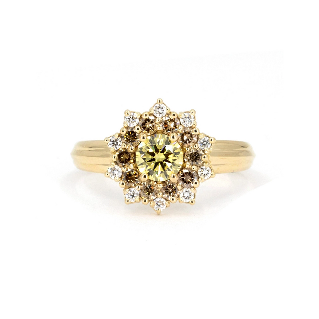 Product photo of a sun-shaped ring on a white background. The ring features a wide yellow gold band and a central round yellow laboratory diamond, surrounded by round gold/brown diamonds and white diamonds. This unique engagement ring is a creation by designer Bena Jewelry.