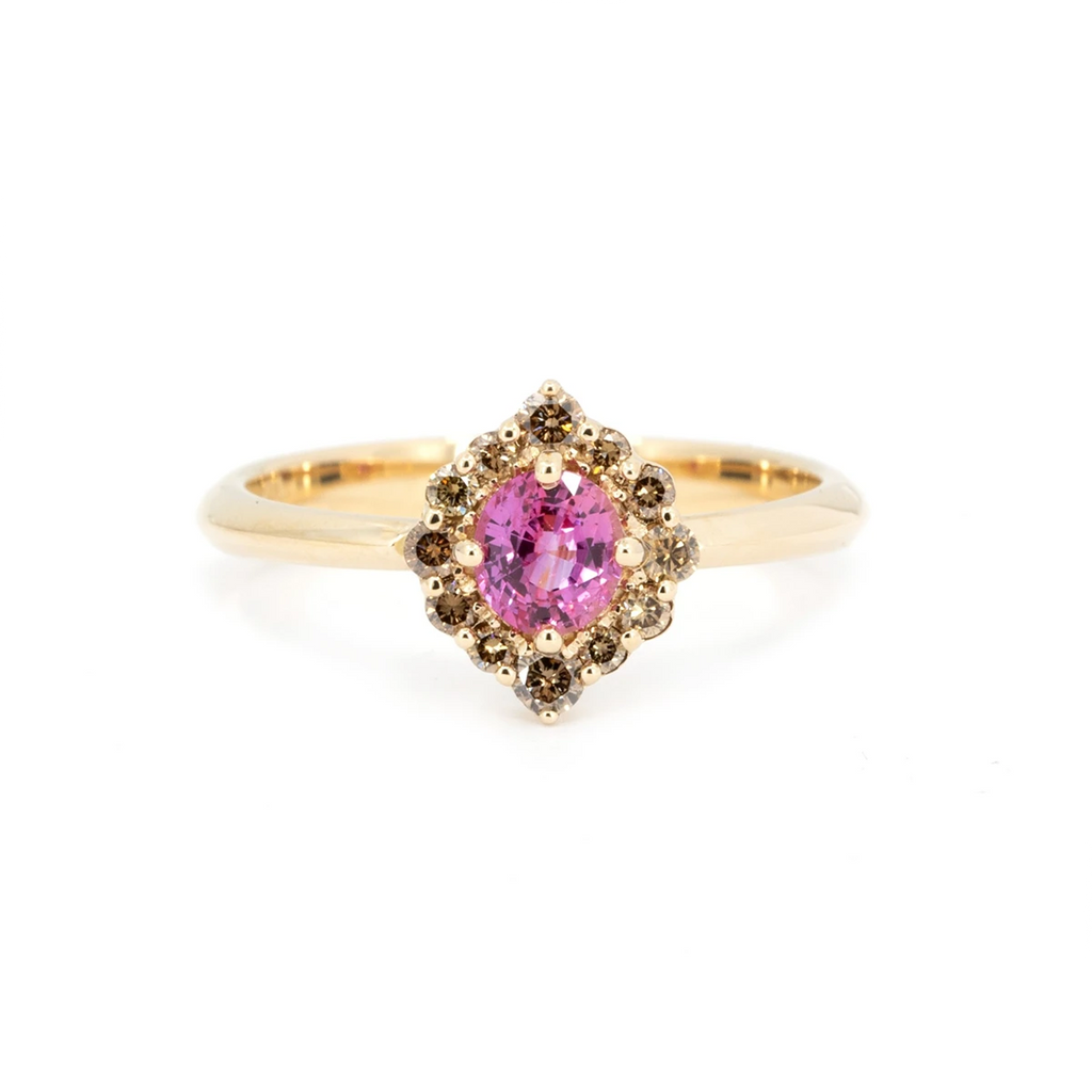 Yellow gold engagement ring with a round pink sapphire at the center, surrounded by a halo of natural brown diamonds in a pointed cluster setting. The design evokes an elegant oriental vibe. Handcrafted in Montreal by Ruby Mardi.