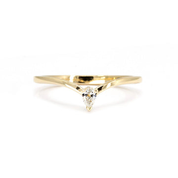 A minimalist yellow gold wedding band featuring a pear-shaped diamond set at the center. The band forms a delicate crown-inspired design, combining modern simplicity with elegance. Handcrafted by RUBY MARDI, an independent jewelry store based in Montreal, specializing in fine, unique pieces.