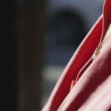 Video of a geo pear light green-blue sapphire pendant in 10K yellow gold catching sunlight, sparkling on skin, Anastassia Sel fine jewelry at Ruby Mardi Montreal