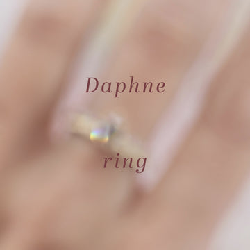 A 12-second video with trumpet music presents a solitaire engagement ring worn on a white woman's hand, stacked with a yellow gold ring that is hand-engraved with a fern motif. The bridal ring features a champagne shield diamond. Both pieces of fine jewelry were created by Fluid Jewellery from Fairmined certified gold. Both jewels from this  independent Canadian brand are available at Canada's hippest jewelry store, Ruby Mardi.