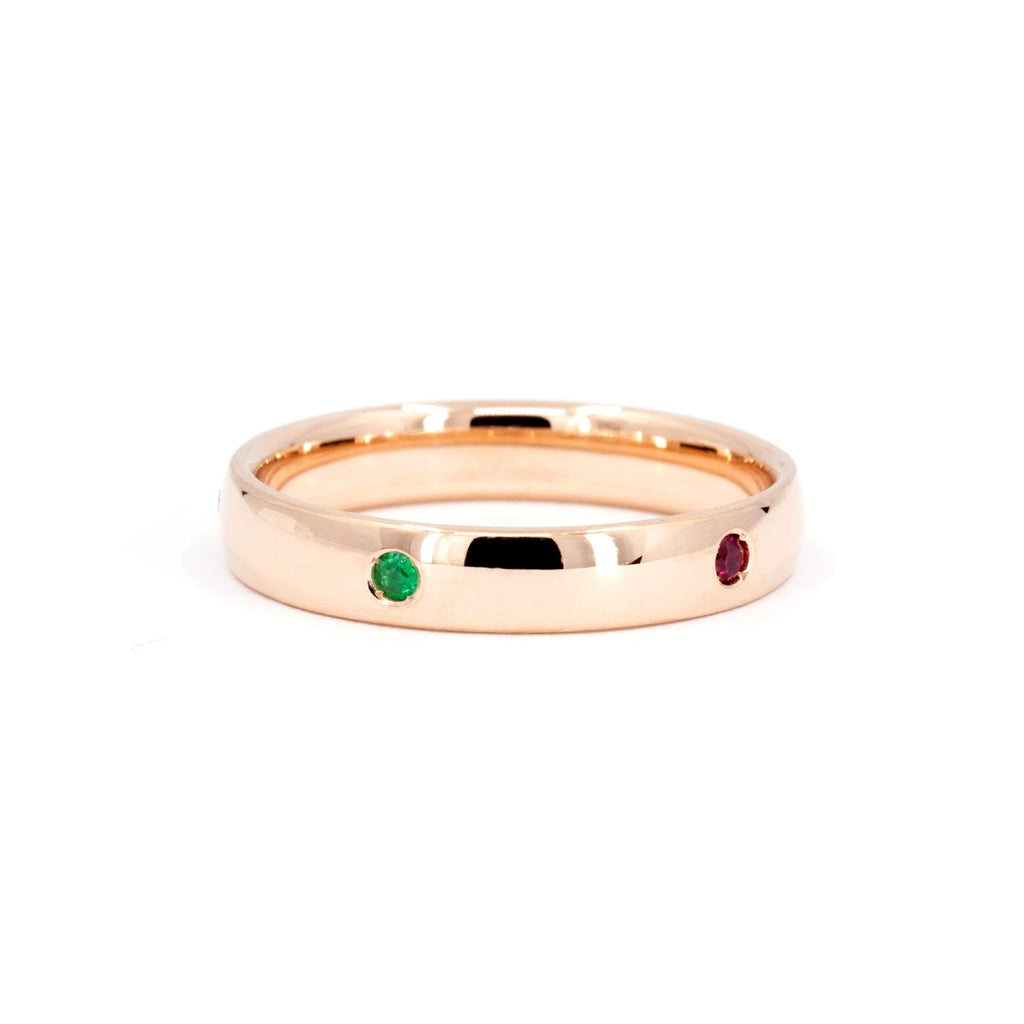 A classic men wedding band in rose gold with the addition of vivid color gemstones (a green garnet and a ruby are showing on the picutre). This unique jewelry piece was designed and handmade in Canada by local independent jewelry brand Ruby Mardi, that offers designer jewelry in Canada and custom jewellery services.