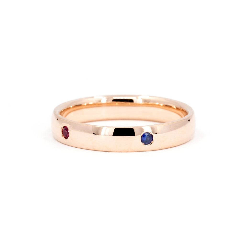 A rose gold wedding band in rose gold with small color gemstones (ruby and sapphire showing on the picture). This ring is an independent jewelry piece handmade in Montreal by local brand Ruby Mardi. We offer unique jewelry in Canada.