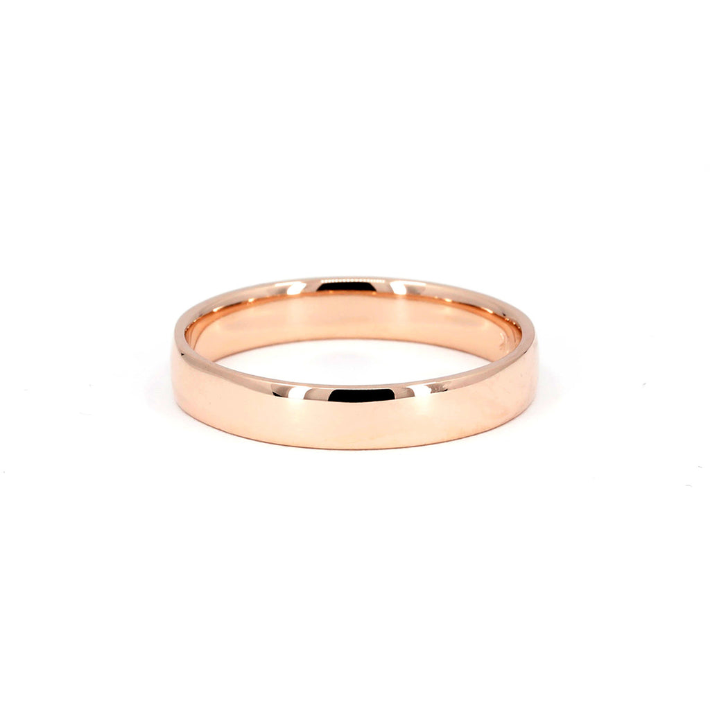 A classic men wedding band in rose gold with a high polish finish, photographed on a white background. This wedding ring was handmade in Montreal by indie jewelry brand Ruby Mardi.