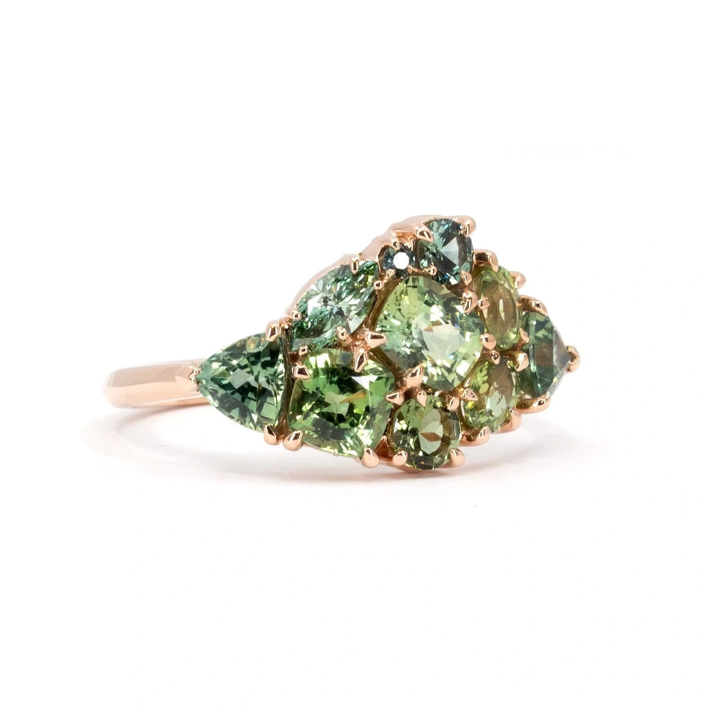 Side view of the Avalanche ring in 14k rose gold, showcasing its artistic cluster of green gemstones, including teal sapphires. A statement piece handcrafted by Ruby Mardi in Montreal.