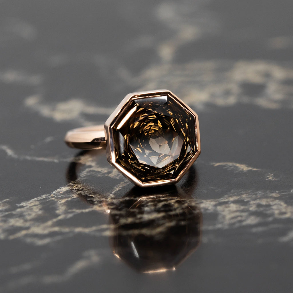 A beautifully handcrafted octagon smoky quartz cocktail ring by Bena Jewelry, set in a sleek rose gold bezel. The faceted gemstone sparkles brilliantly, creating a bold and elegant statement piece. Available exclusively at Ruby Mardi, a boutique for unique artisan jewelry.