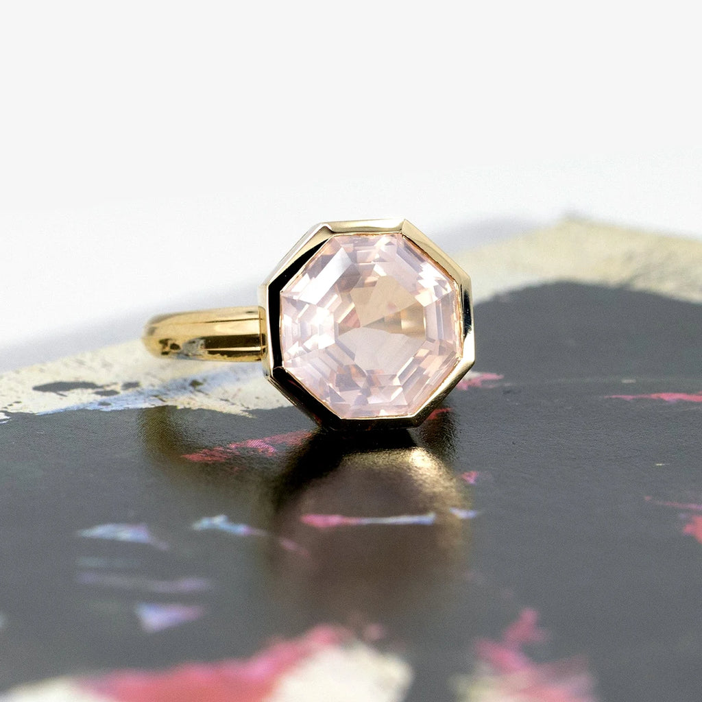 Yellow gold rose quartz statement ring photographed on an abstract background. The ring of an octogonal shape is bold and stunning. It's a creation from Bena Jewelry and it's available at independent Canadian jewelry store Ruby Mardi.