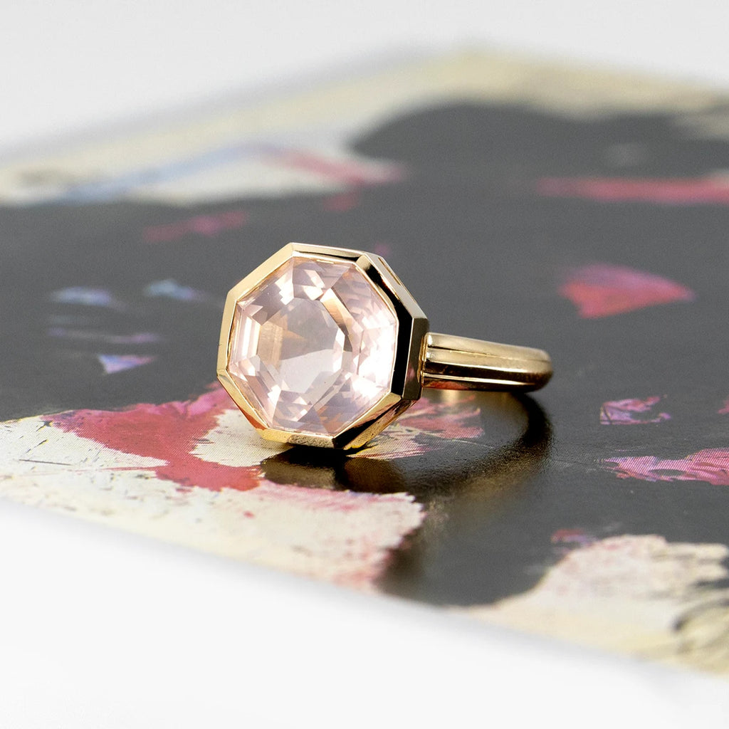 Yellow gold rose quartz statement ring photographed on an abstract background. The ring of an octogonal shape is bold and stunning. It's a creation from Bena Jewelry and it's available at independent Canadian jewelry store Ruby Mardi.