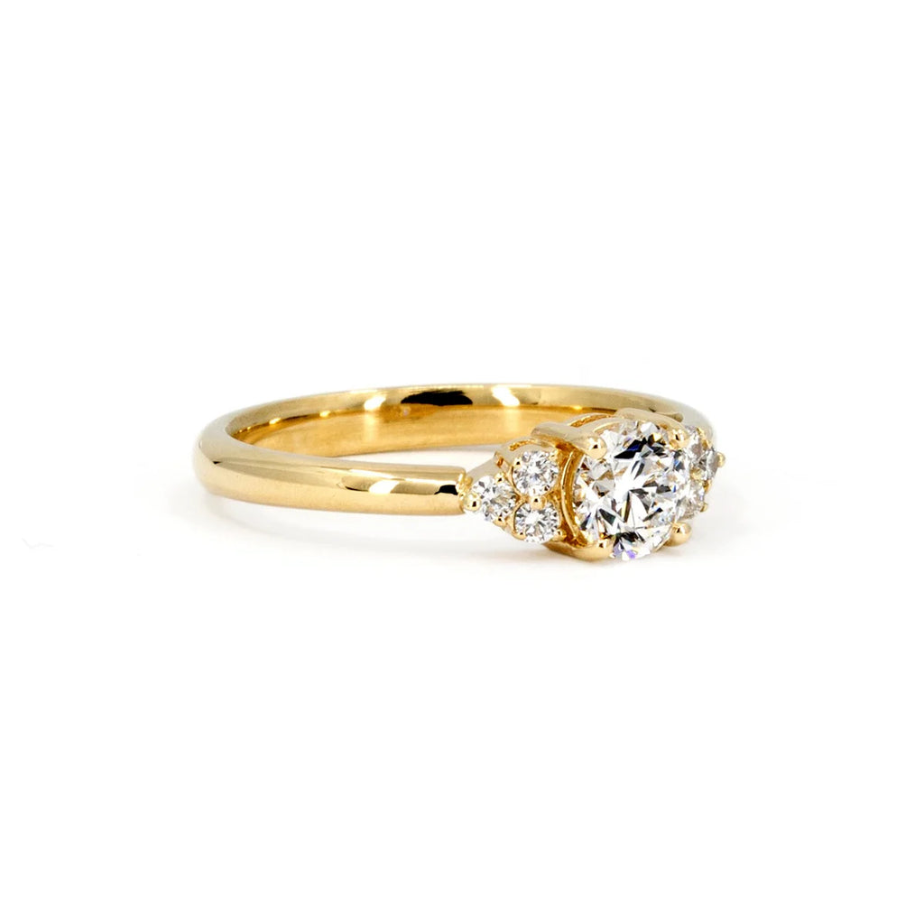 Side view on a white background of a classic round diamond engagement ring in yellow gold. This Canadian jewelry piece was designed in Montreal for Ruby Mardi, the best jewelry brand in Canada, that offers designer jewels and custom jewellery services.