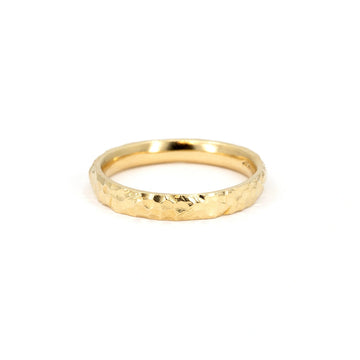 A hammered yellow gold wedding band, handcrafted by Sheena Purcell with a rustic, textured finish, available at Ruby Mardi.