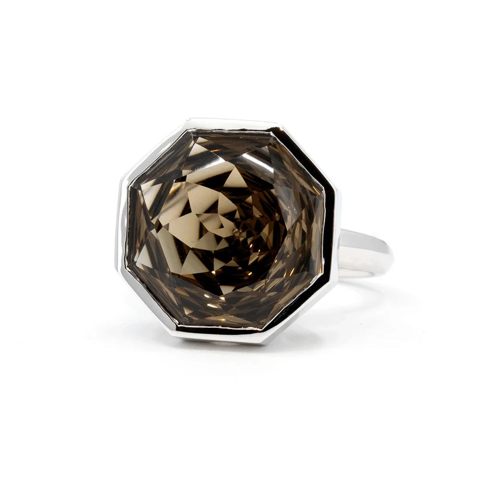 A huge designer cocktail ring made in Canada by independent brand Bena Jewelry. It features a big smoky quartz of an octogonal shape bezel set in 14k white gold. This unique statement ring is photographed on a white background. It's available at Canadian jewelry store Ruby Mardi.
