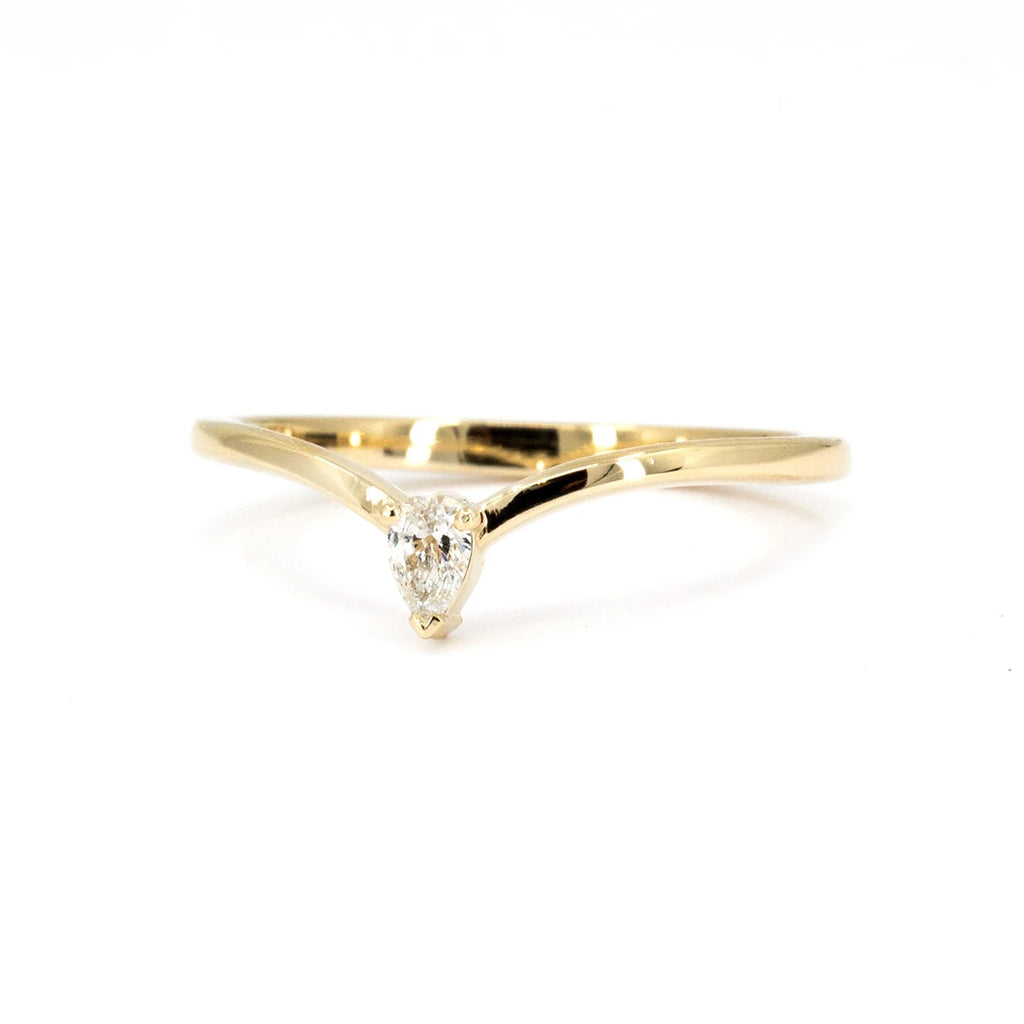 A sleek yellow gold wedding band featuring a pear-shaped diamond in a minimalist design. This handcrafted piece from RUBY MARDI is designed in Montreal, showcasing modern elegance and fine craftsmanship.