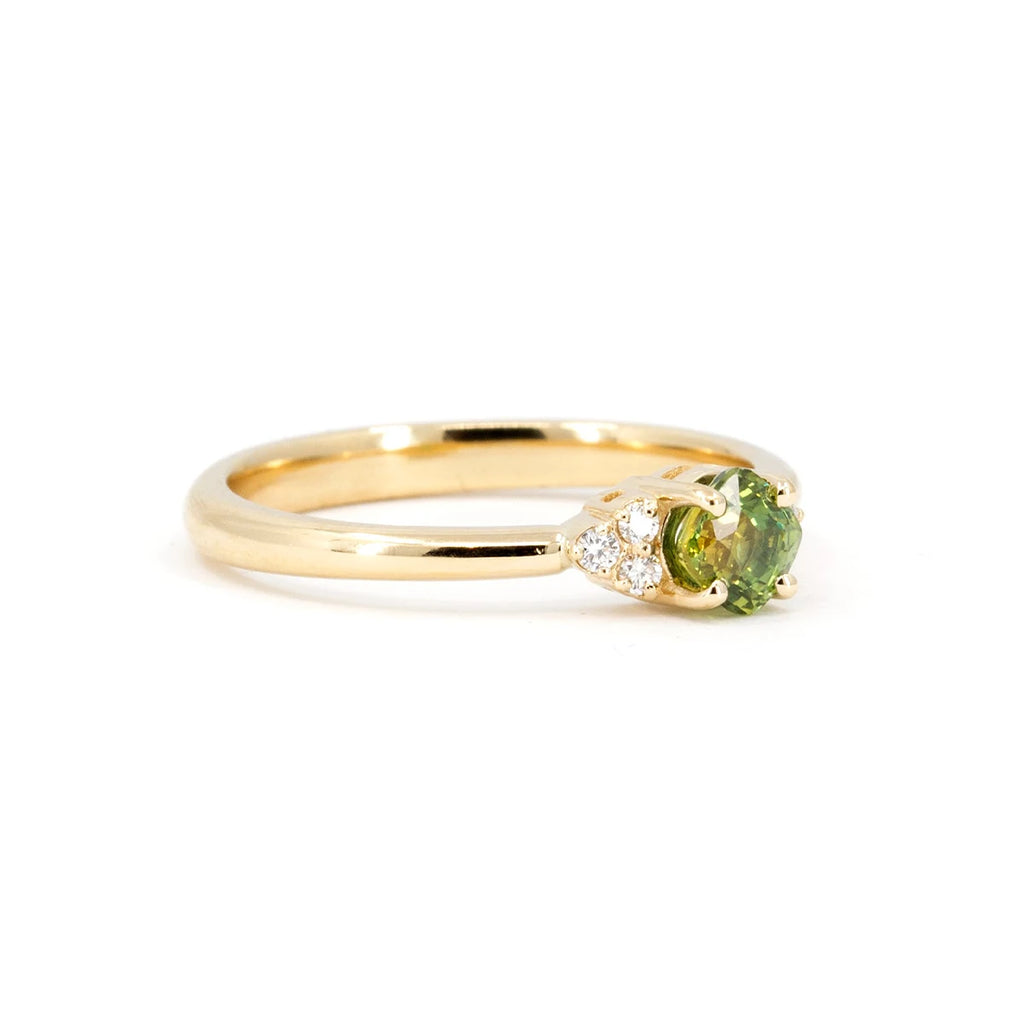 Cushion shape sapphire set in yellow gold. This engagement ring is seen from its side and is photographed on a white background. It's a creation from Canadian jewelry brand Ruby Mardi. Unique jewelry in Canada.