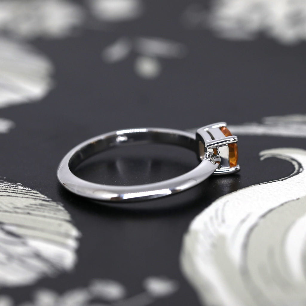 back view of colored orange spessartite garnet bridal custom made engagement ring by ruby mardi fine jewellery designer in montrel little italy on a dark background