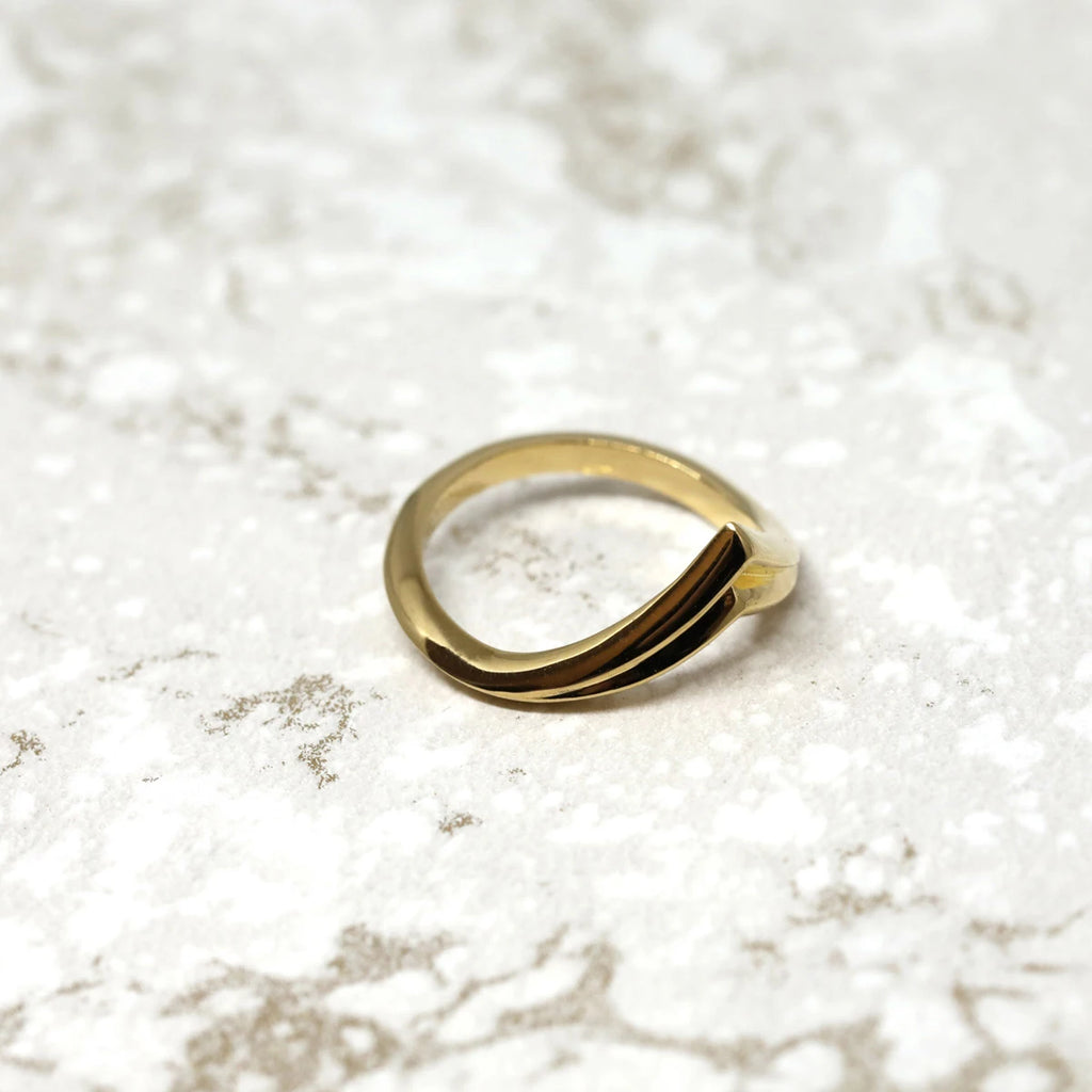 top view of a vermeil gold adorn edgy ring made in montreal on a marble background
