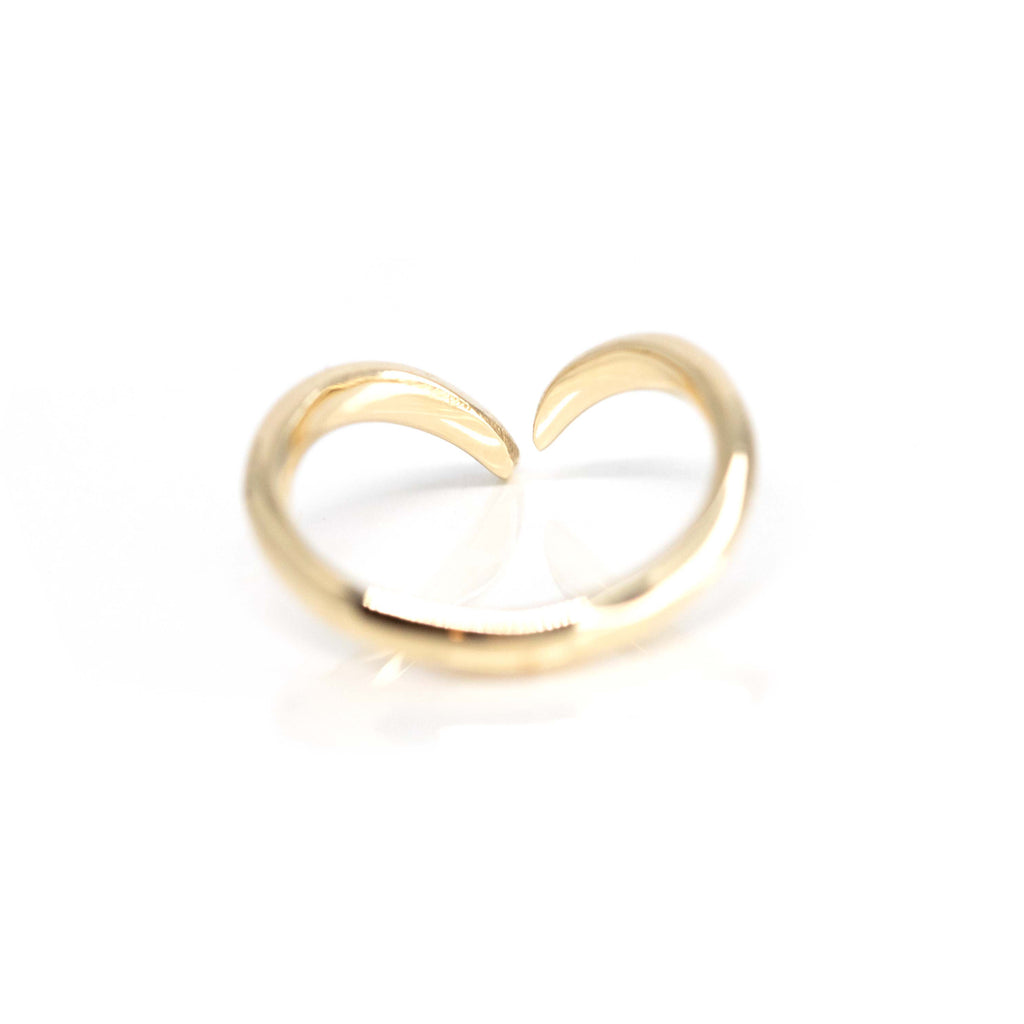 Back view of an open gold ring wedding band. It is photographed on a white background. 