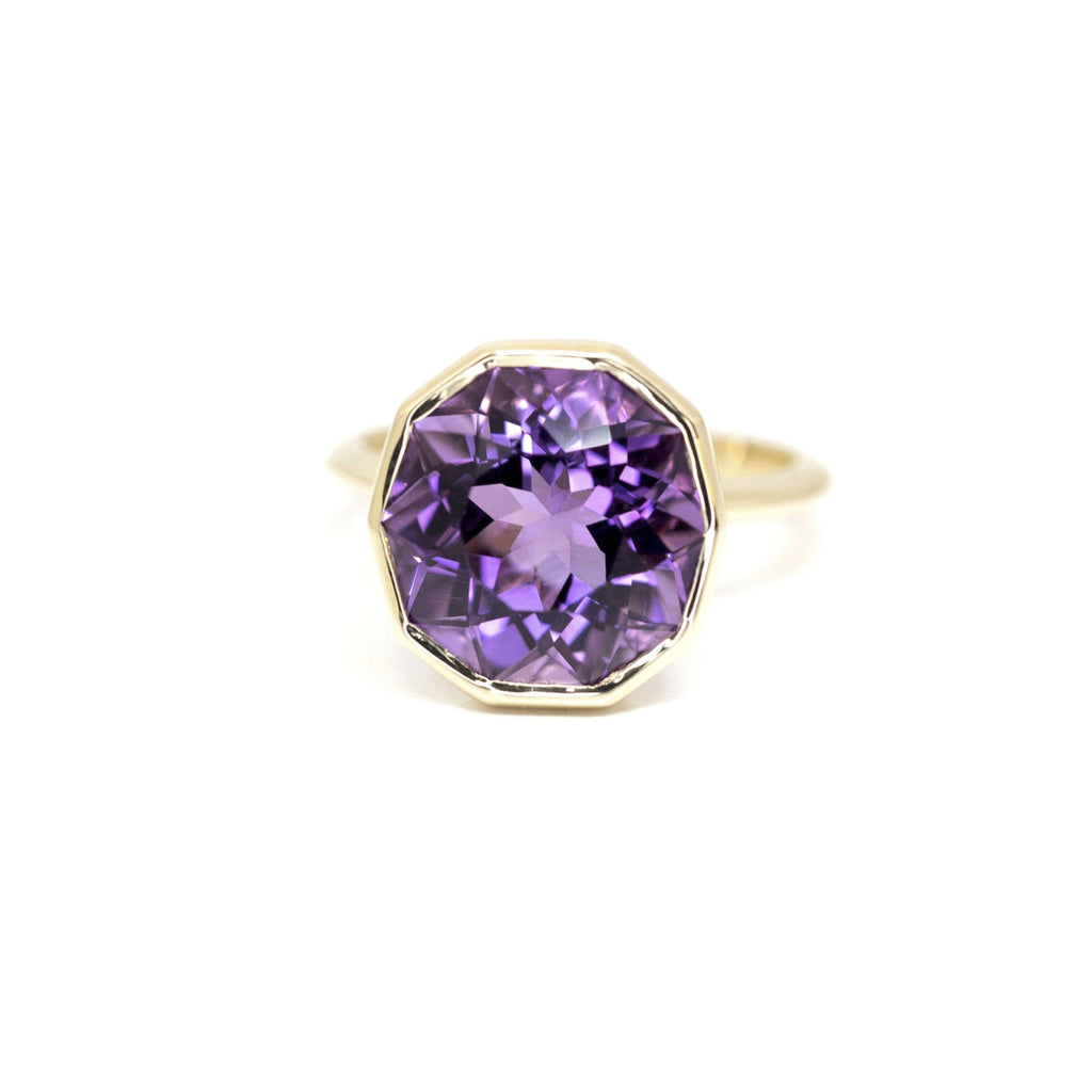 front view of round fancy amethyst unique statement ring made in montreal jewelry online store on a light pink background