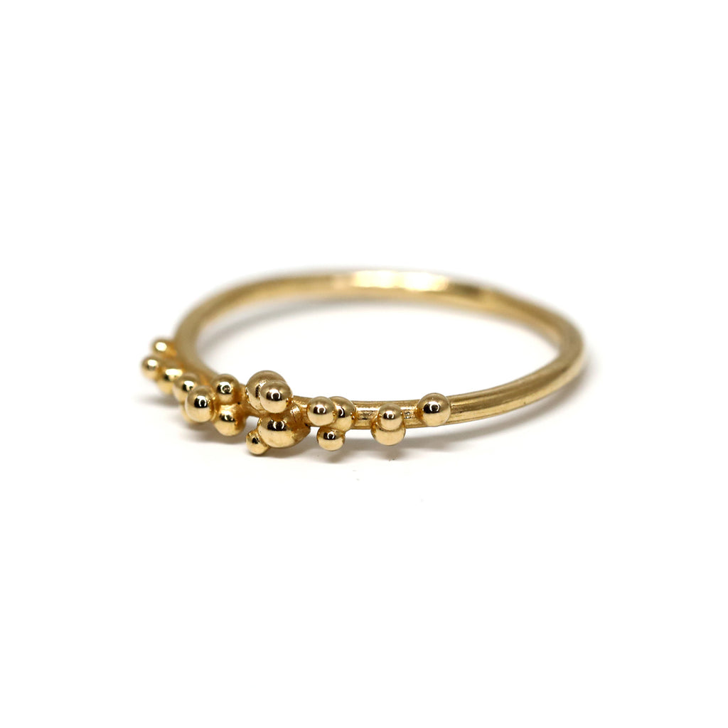 Yellow gold Areia delicate ring on a white background by Toronto-based jewelry designer Meg Lizabet. Organic ring with hand-placed gold granules. 14K yellow gold ring, original wedding band or engagement ring. Unique ring that cannot be reproduced. Find Meg Lizabet's creations in Montreal at Ruby Mardi, a boutique-gallery in Montreal's Little Italy, not far from Rosemont, Villeray, Outremont, Mile End. Custom jewelry design services in Montreal also available.