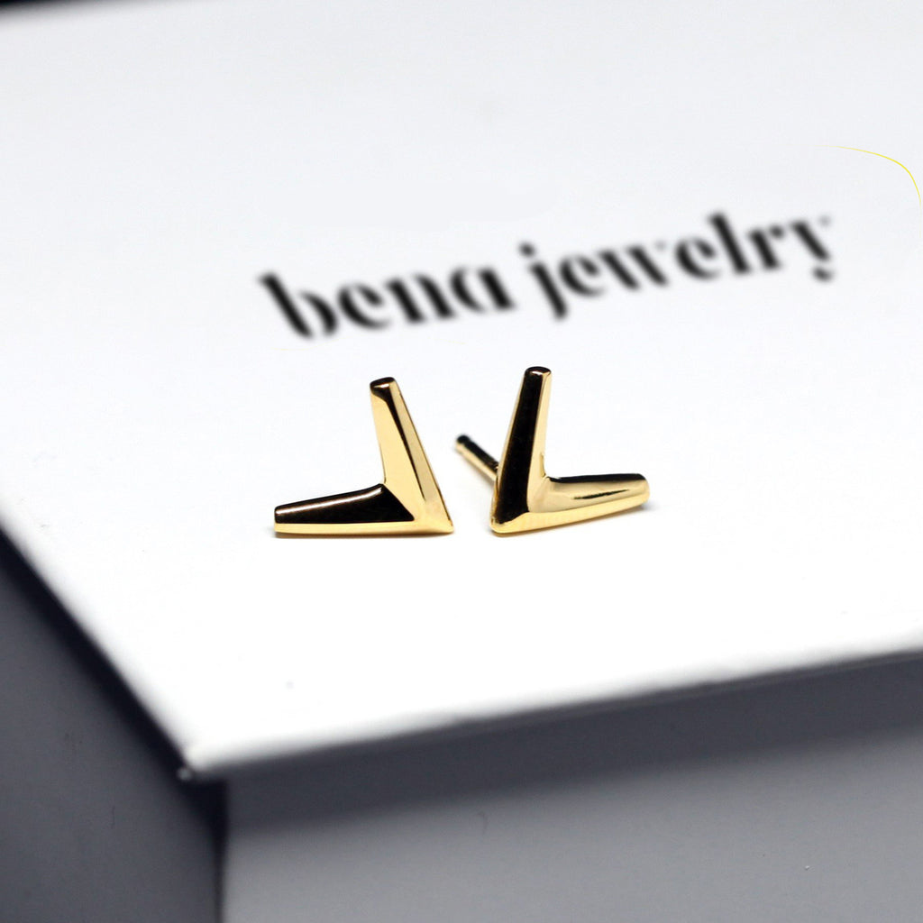 Simple gold vermeil arrow earrings in V shape on its box. Unisex jewelry pieces for parties and for everyday wear. Available online or at our Montreal's Little Italy store, with the work of other jewelry designers. We also offers custom jewelry services in Montreal.