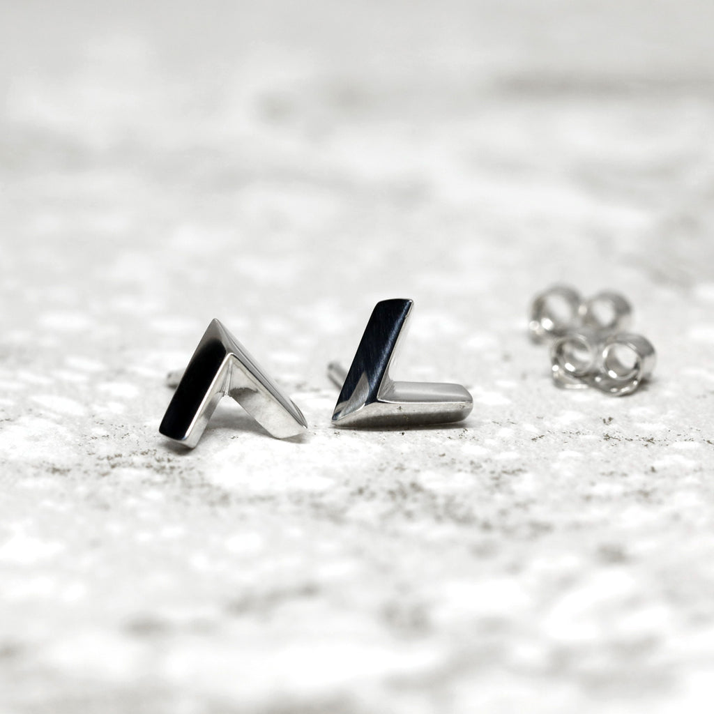 Simple sterling silver arrow earrings in V shape on a white background. Unisex jewelry pieces for parties and for everyday wear. Available online or at our Montreal's Little Italy store, with the work of other jewelry designers. We also offers custom jewelry services in Montreal.