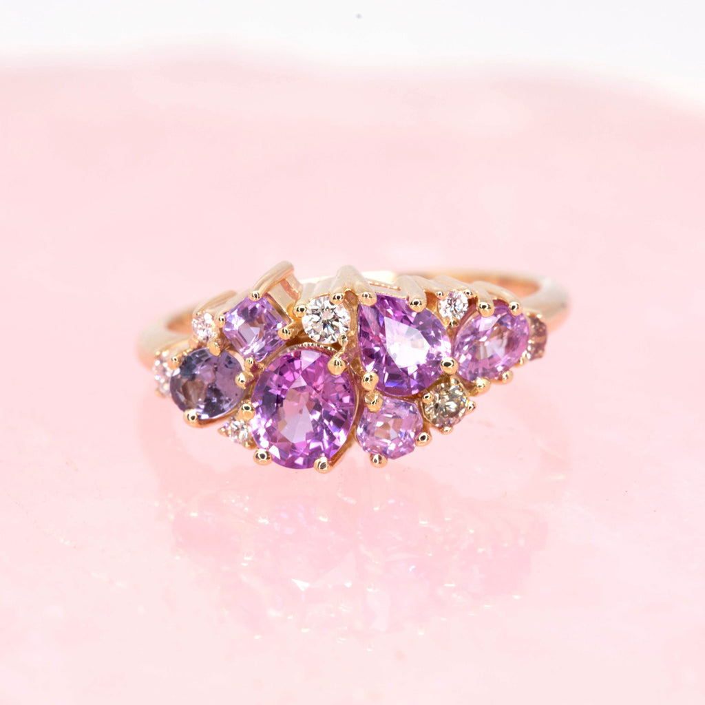 The avalanche ring by Ruby Mardi seen on pink quartz. This 14k yellow gold ring would make a unique engagement ring. It features 12 natural gemstones in pink and violet hues. See more one-of-a-kind rings at our store in Montreal’s Little Italy.