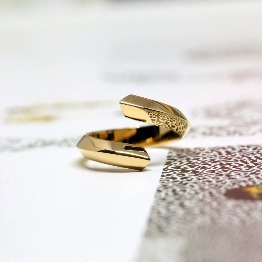 La bague Loop en or vermeil du créateur de bijoux canadien Bena Jewelry, photographiée sur un fond funky. Bijou moderne et prédominant fabriqué à la main disponible à la bijouterie fine Ruby Mardi, en ligne ou dans la Petite Italie de Montréal.