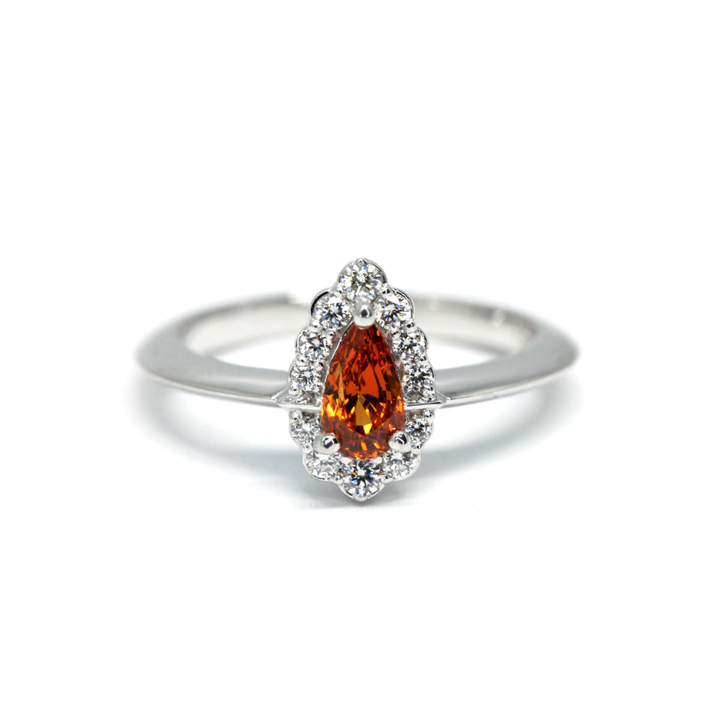 Spessartite Orange Garnet Engagement ring with a diamond halo on a white background by Ruby Mardi, a fine jewelry gallery in Montreal Little Italy. White gold gemstone ring, bridal jewelry, wedding ring, ethical gem. Ruby Mardi offers custom jewelry services in Montreal. Lab grown diamonds, natural diamonds, Canadian diamonds, ethical diamonds, ethical gemstones.