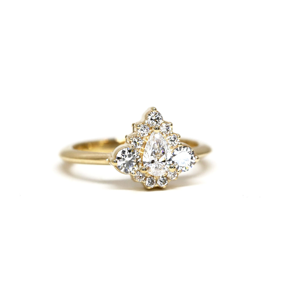 lab grown pear shaped yellow gold diamond engagement ring custom made in montreal at ruby mardi fine jewellery bespoke bridal designer on a white background