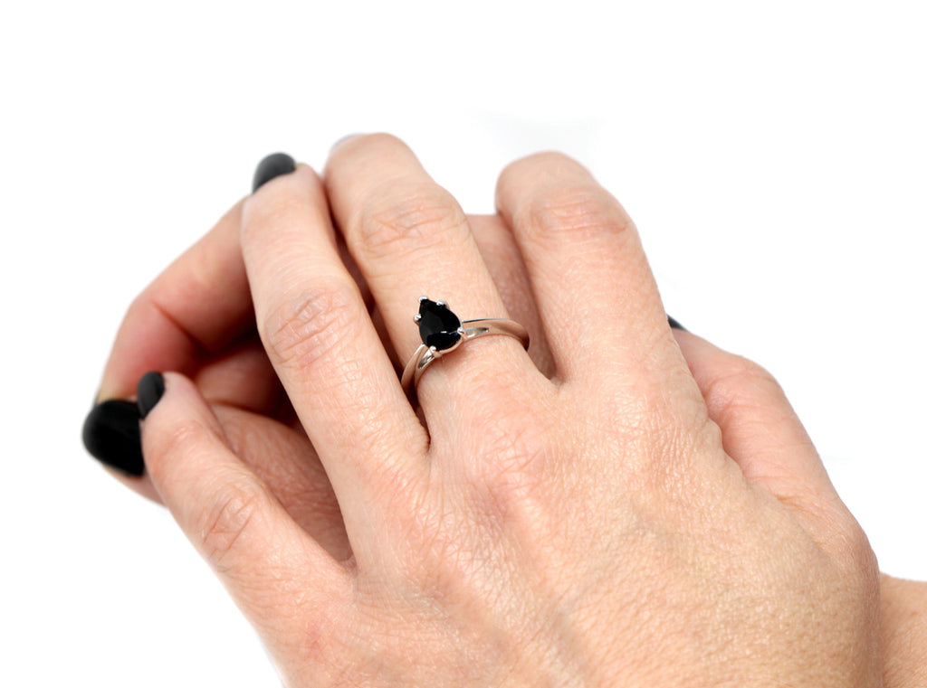 girl wearing a black pear white gold engagement ring custom made bridal in montreal by ruby mardi jeweller in little italy on a white background