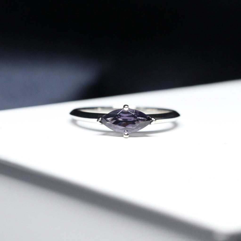Marquise Shape Dark Purple Spinel Engagement ring with a diamond halo on a white background by Ruby Mardi, a fine jewelry gallery in Montreal Little Italy, close by Bijouterie Italienne, and Rosemont, Outremont, Villeray, Parc Extension, Mile End, Mile Ex districts. White gold gemstone ring, bridal jewelry, wedding ring, ethical gem. Ruby Mardi offers custom jewelry services in Montreal. Lab grown diamonds, natural diamonds, Canadian diamonds, ethical diamonds, ethical gemstones.
