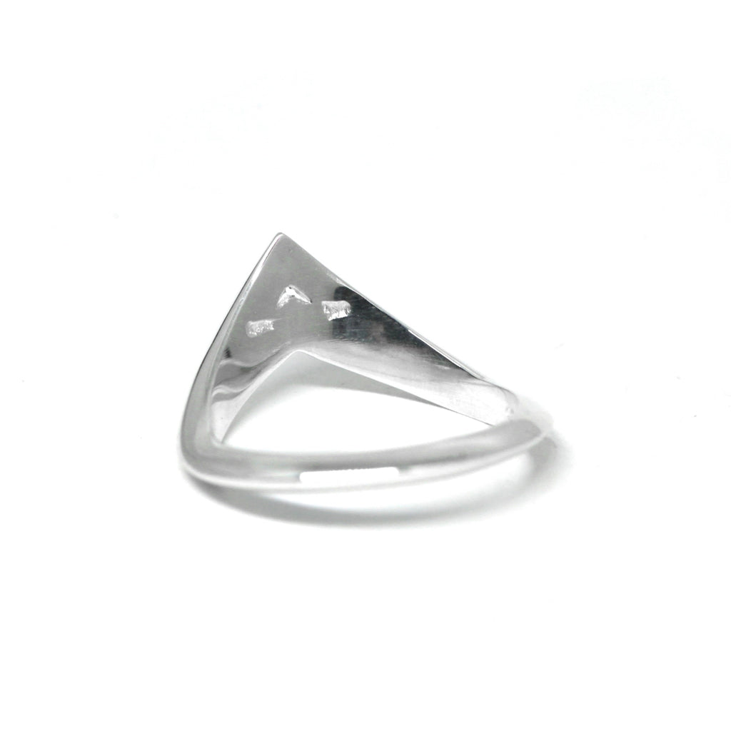 back view of a silver ring with an edgy shape on a white background