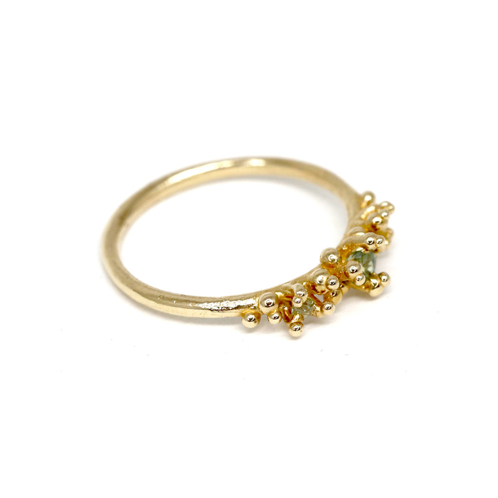 Areia ring on a white background by Toronto-based jewelry designer Meg Lizabet. Organic ring with hand-placed gold granules. 14K yellow gold ring with encapsulated green and yellow sapphires. Unique ring that cannot be reproduced. Find Meg Lizabet's creations in Montreal at Ruby Mardi, a boutique-gallery in Montreal's Little Italy, not far from Rosemont, Villeray, Outremont, Mile End. Custom jewelry design services in Montreal also available.