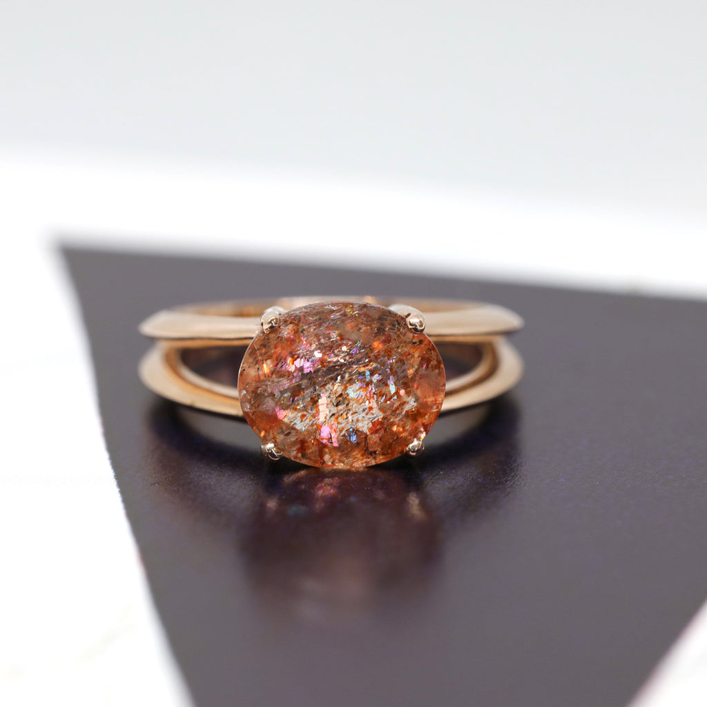 Product photography of a beautiful ring in 14k rose gold featuring a huge oval sunstone, by designer Bena Jewelry. Find the most exquisite designer jewelry at Ruby Mardi, a fine jewelry store in Montreal that presents the work of the most talented Canadian jewelry designers. Custom jewelry services also offered.