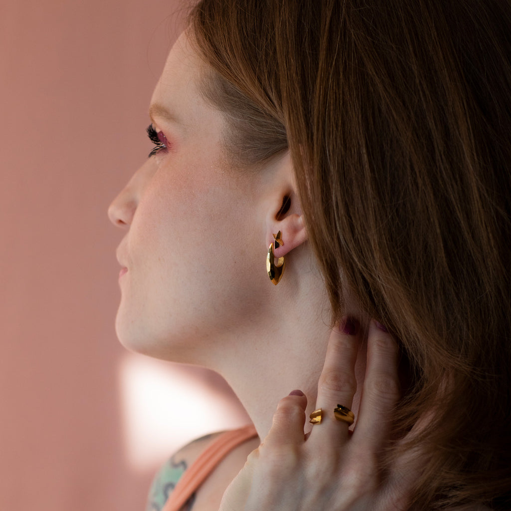 Une jeune femme moderne porte des bijoux en or vermeil fabriqués à la main à Montréal par le créateur Bena Jewelry, et disponible à la bijouterie Ruby Mardi, dans la Petite Italie de Montréal.
