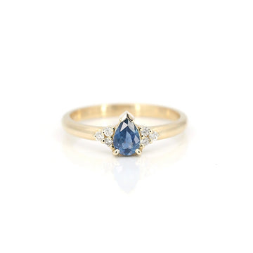 Blue sapphire yellow gold engagement ring with diamond accents, photographed on a white background. Handmade in Toronto by Arsaeus Designs, and available in Montreal at fine jewelry store Ruby Mardi. One-of-a-kind gold ring.