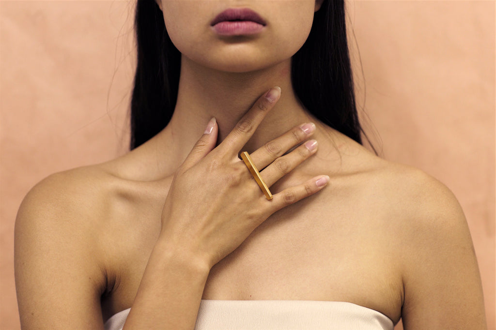 Fashion shot of PUNCH RING, a modern statement gold vermeil ring also available in sterling silver and solid gold. Fine jewelry handmade in Montreal and available online for worldwide shipping. A gender-neutral piece of jewelry that fits both classic and edgy wardrobes that you can rock everyday. 